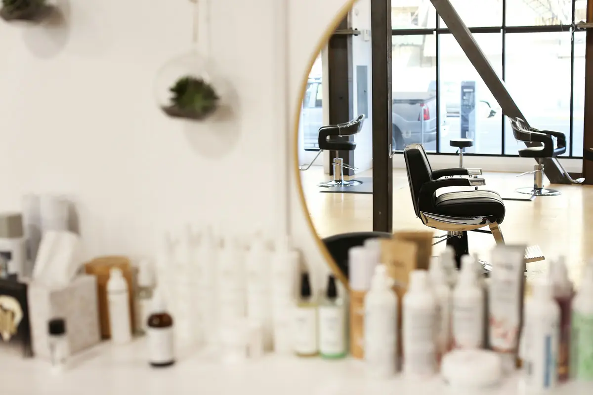 Produits de soin et fauteuils devant un grand miroir rond
