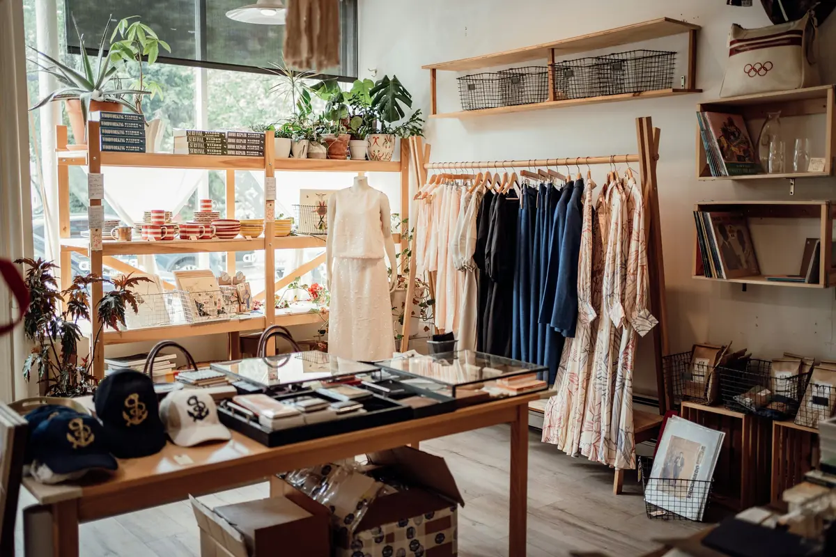 Intérieur d'une boutique de vêtements avec portants et étagères en bois