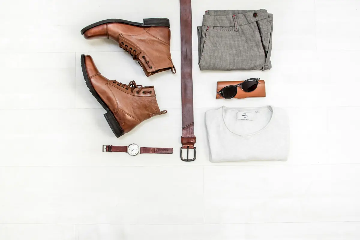Bottines, ceinture, montre et lunettes de soleil posées à plat
