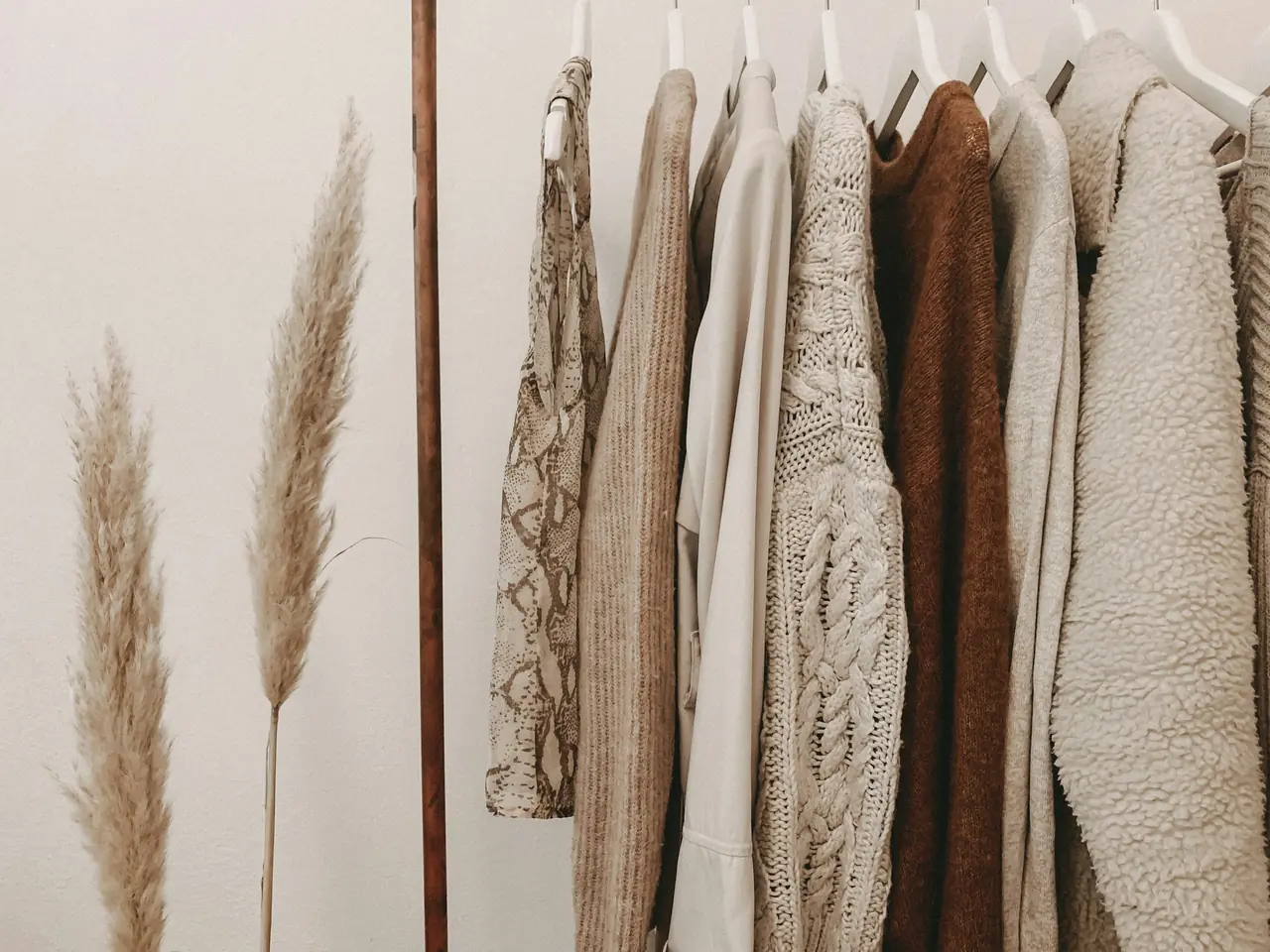 Pulls en maille et gilets aux tons naturels sur un portant