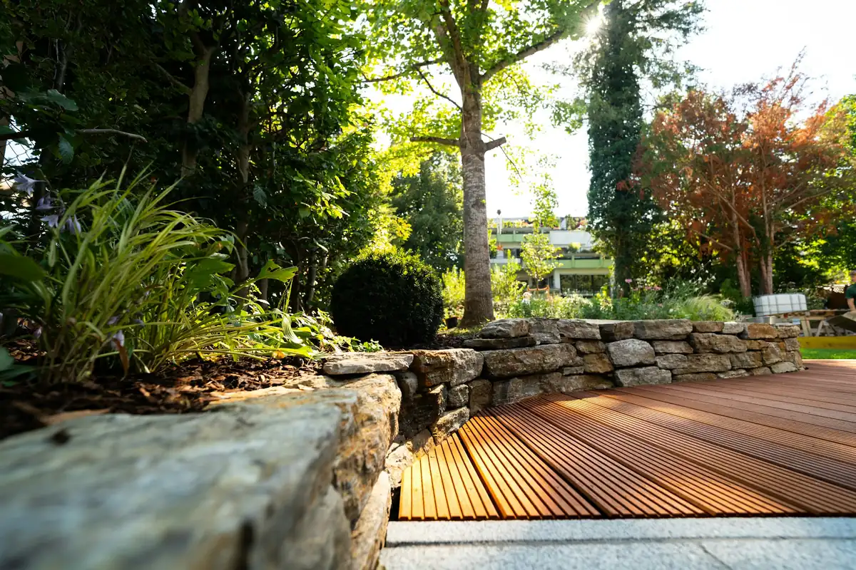 Terrasse en bois bordée d'un muret en pierres sèches