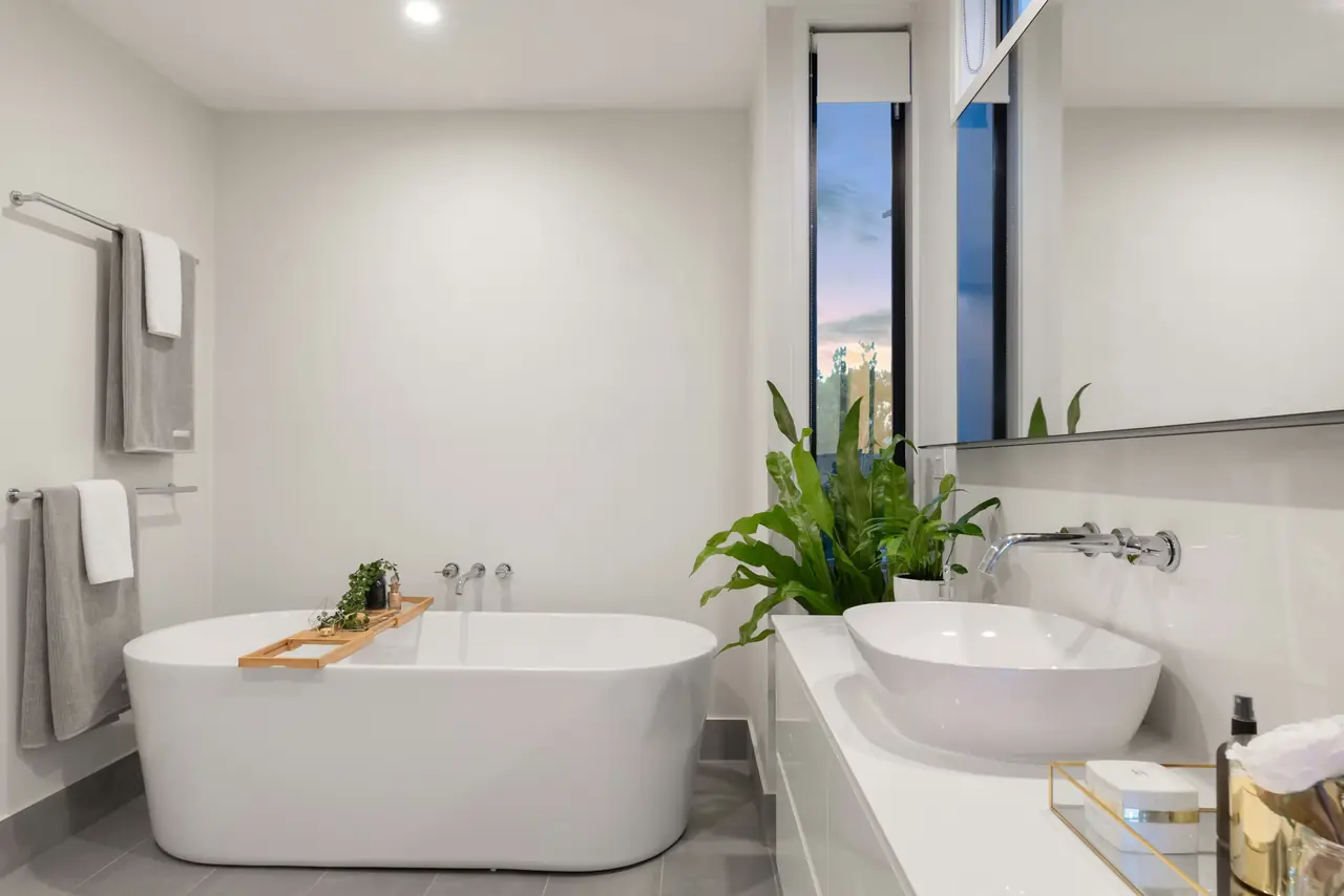 Salle de bains blanche rénovée, avec baignoire îlot et vasque posée